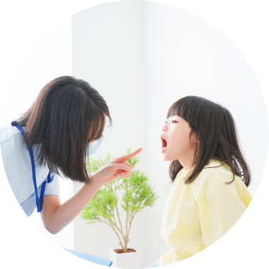 女性の歯科医が女の子の診察をしている写真