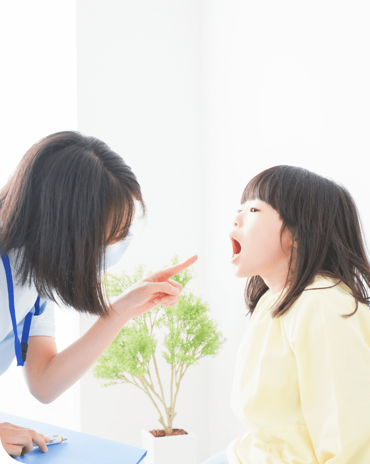 医師が女の子の喉を診察している様子